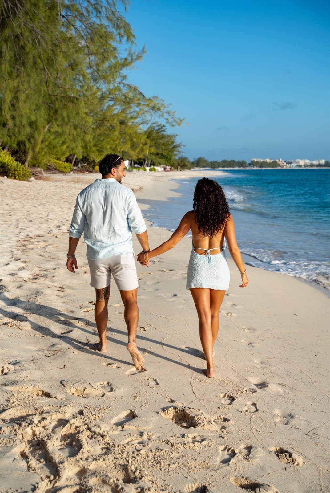 Carlos and Maise walking together along the beach